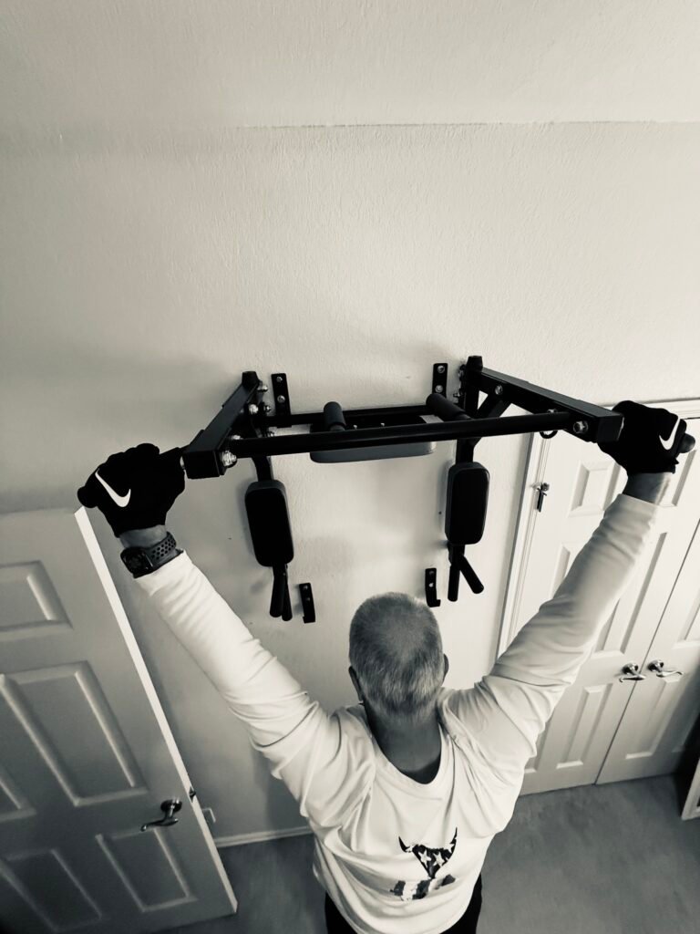 Man experiencing dead hang benefits including back relief and shoulder mobility at home
